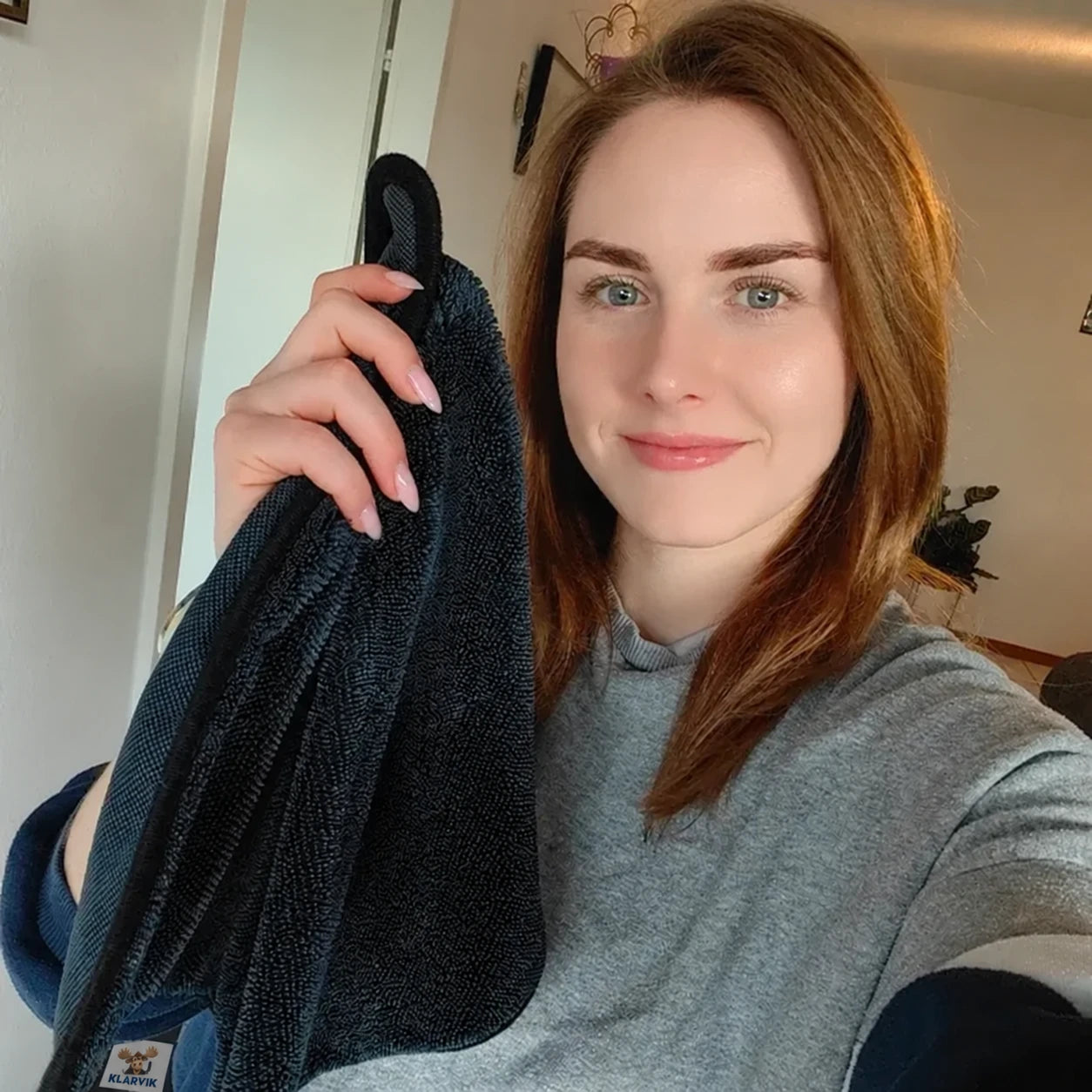 En kvinna håller en svart rengöringsduk